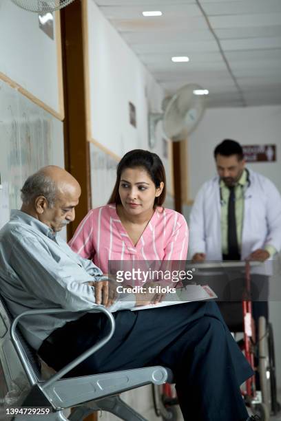 daughter consoling sad senior man in waiting room - asian waiting angry expressions stock pictures, royalty-free photos & images