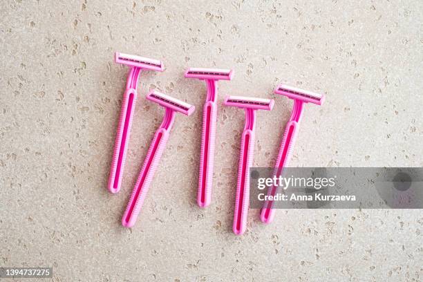 group of disposable pink razors on concrete background, top view. copy space. shaving concept - lâmina de barbear imagens e fotografias de stock