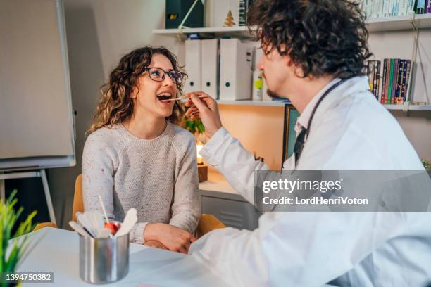 médico que toma un hisopo de garganta - spit fotografías e imágenes de stock