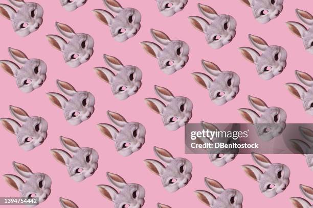 hare rabbit masks pattern with hard shadow on pink background. disguise, masquerade, carnival, easter and fun concept. - easter bunny mask stockfoto's en -beelden