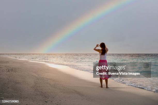 woman photographing rainbow on a tropical beach. - landscap with rainbow fotografías e imágenes de stock