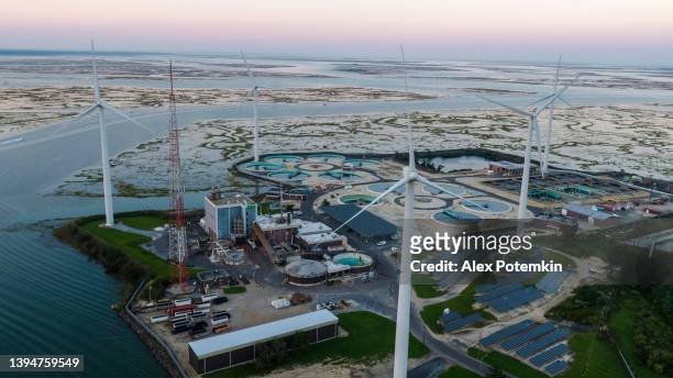 sustainable energy is used in environmental conservancy. a wastewater treatment plant powered by wind turbines and solar panels near atlantic city in new jersey, usa. - zonne eiland stockfoto's en -beelden
