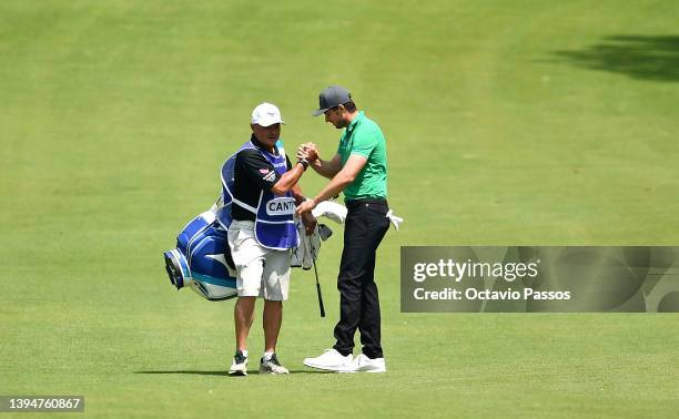 Laurie Canter of England celebrates with caddie Kyle Roadley after holing his third shot for an eagle on the third hole during the final round of the...