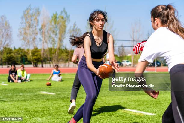 girls playing an intense game of rugby on the field with their friends - female rugby team stock pictures, royalty-free photos & images