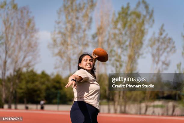 girls playing an intense game of rugby on the field with their friends - throwing football stock pictures, royalty-free photos & images