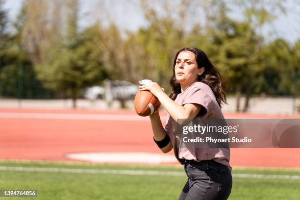 girls playing an intense game of rugby on the field with their friends - american football ball studio stock pictures, royalty-free photos & images