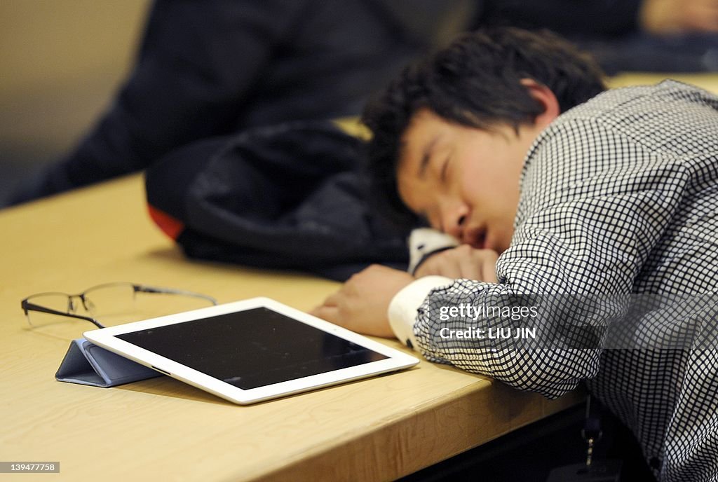 A man takes a nap next to his Ipad at a