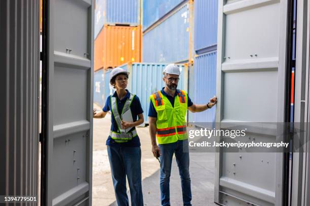 two warehouse worker opening empty shipping container at shipping yard. - open shipping container stock pictures, royalty-free photos & images