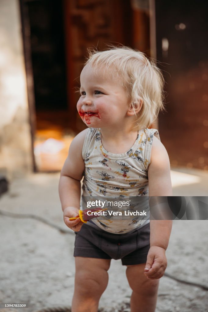 Little boy eats ice-cream outside