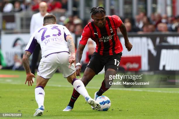 Rafael Leao of AC Milan runs with the ball from Lorenzo Venuti of Fiorentina during the Serie A match between AC Milan and ACF Fiorentina at Stadio...