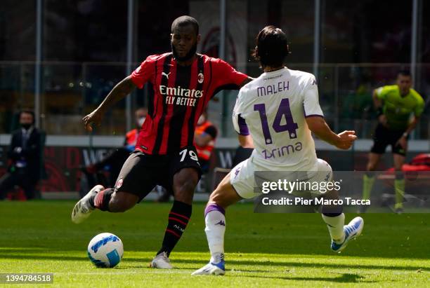 Franck Kessie of AC Milan is tackled by Youssef Maleh of ACF Fiorentina during the Serie A match between AC Milan and ACF Fiorentina at Stadio...