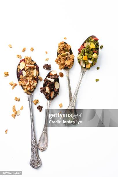 granola with nuts and dried fruits on spoons - granola stockfoto's en -beelden