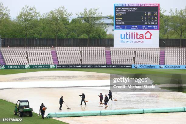 Groundstaff sweep water off the cover as rain delays play during day four of the LV= Insurance County Championship match between Hampshire and...