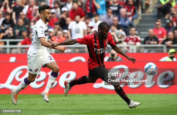 Franck Kessie of AC Milan is challenged by Lorenzo Venuti of Fiorentina during the Serie A match between AC Milan and ACF Fiorentina at Stadio...