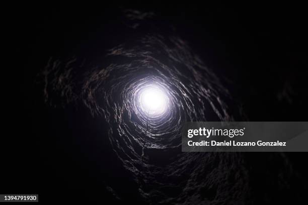 dark round tunnel with light - enge stock-fotos und bilder