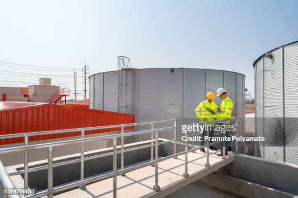 civil and engineer  stand in water tanks utilities of industry, use digital tablet computer, have discussion. large water tanks assembled. design and construction of water tanks transport pipeline. - reservoir engineering stock pictures, royalty-free photos & images