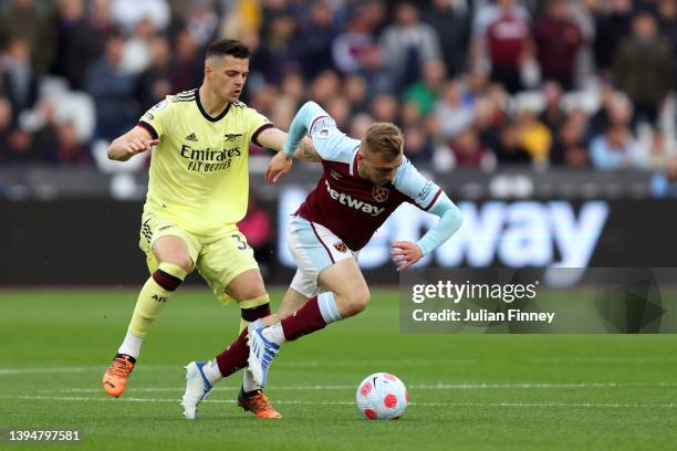 Granit Xhaka of Arsenal challenges Jarrod Bowen of West Ham United during the Premier League match between West Ham United and Arsenal at London...