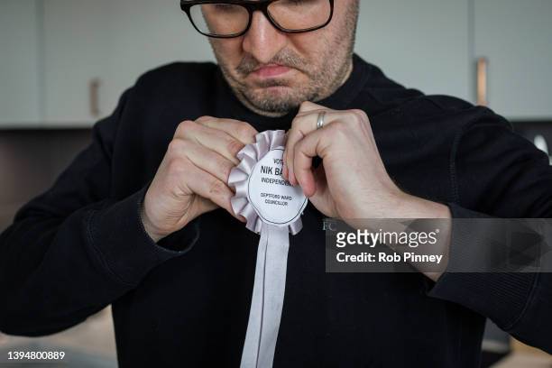 Independent candidate for Deptford ward in Lewisham Nik Baksi pins a rosette to his sweatshirt before leaving home on May 01, 2022 in London,...