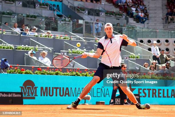 John Isner of USA returns a ball to Filip Krajinovic of Serbia during Day Four of Mutua Madrid Open at La Caja Magica on May 01, 2022 in Madrid,...