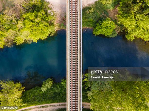 vías de ferrocarril cruzando un hermoso río en primavera - rail fotografías e imágenes de stock