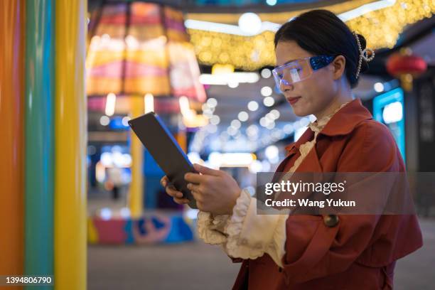 young business woman wearing augmented reality glasses is using tablet at night - taiwan business stock pictures, royalty-free photos & images