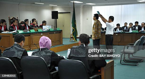 Indonesian Youth and Sports Minister Andi Mallarangeng is sworn under the Koran in front of the judges at a corruption court in Jakarta on February...