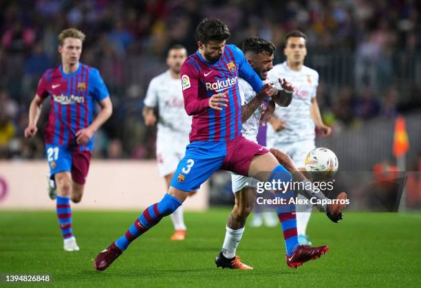 Gerard Pique of FC Barcelona battles for possession with Antonio Sanchez of Real Mallorca during the LaLiga Santander match between FC Barcelona and...