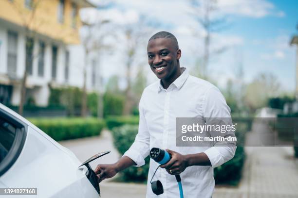 hombre cargador de coche eléctrico - cable car fotografías e imágenes de stock