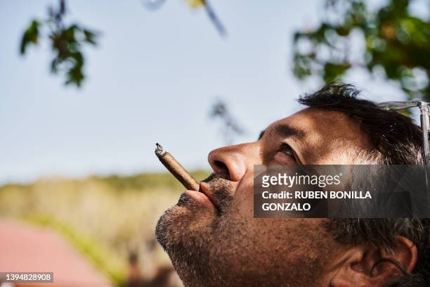 portrait of mid adult man smoking a cigar against sky. relax concept. - gonzalo caballero fotografías e imágenes de stock