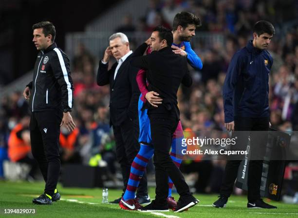 Gerard Pique of FC Barcelona interacts with Xavi, Head Coach of FC Barcelona after being substituted during the LaLiga Santander match between FC...