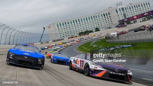 Chris Buescher, driver of the Fastenal Ford, and Denny Hamlin, driver of the FedEx Office Toyota, lead the field on a pace lap prior to the NASCAR...