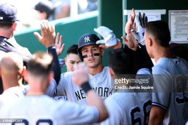 Anthony Rizzo of the New York Yankees is congratulated by teammates in the dugout after scoring during the 7th inning of the game against the Kansas...