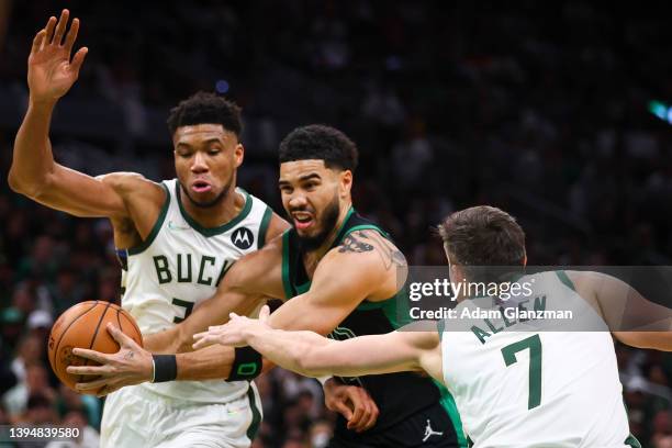 Jayson Tatum of the Boston Celtics drives to the basket past Giannis Antetokounmpo and Grayson Allen of the Milwaukee Bucks during a game at TD...