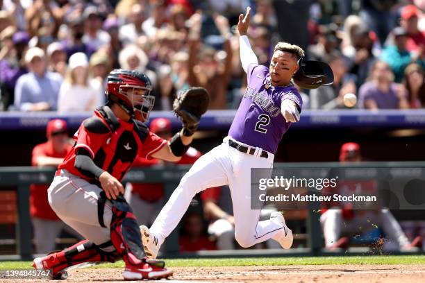 Yonathan Daza of the Colorado Rockies scores scores past catcher Mark Kolozsvary of the Cincinnati Reds on a Brendan Rodgers three RBI double in the...