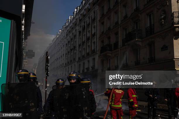 Firefighters extinguish a fire during a May Day rally on May 01, 2022 in Paris, France. Protests on International Workers' Day are an annual event in...