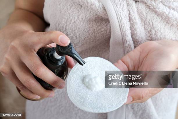 woman using ecological reusable washable make-up remover pads to cleanse her skin with lotion or cream - cotton pad stock pictures, royalty-free photos & images