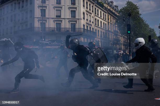 Riot police officers chase a protester as tear gas is deployedduring a May Day rally on May 01, 2022 in Paris, France. Protests on International...
