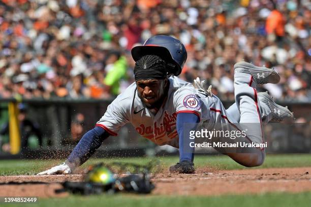 Lucius Fox of the Washington Nationals slides into home after a wild pitch from Yunior Marte of the San Francisco Giants during the top of sixth...