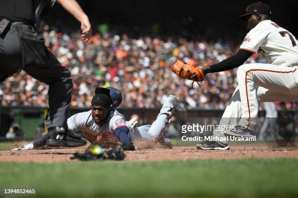Lucius Fox of the Washington Nationals slides into home after a wild pitch from Yunior Marte of the San Francisco Giants during the top of sixth...