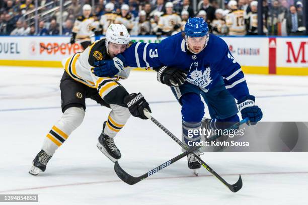 Justin Holl of the Toronto Maple Leafs battles against Anton Blidh of the Boston Bruins during the third period at the Scotiabank Arena on April 29,...