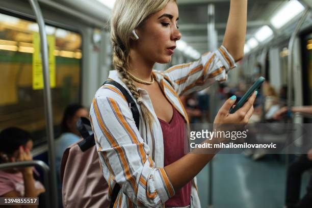 alone time in the subway - headphones woman stockfoto's en -beelden