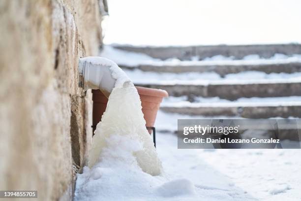 frozen pipe on snowy street - frozen pipes foto e immagini stock