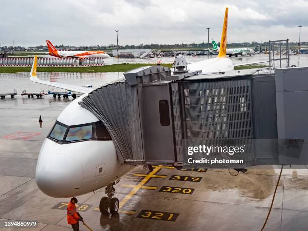airport ground technician checking airplane body at passenger boarding bridge - airbus stock symbol stock pictures, royalty-free photos & images