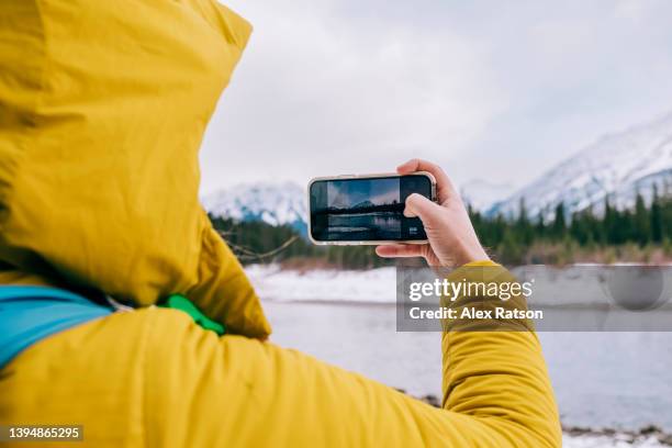 looking over the shoulder of a person taking a photo of a scenic winter vista in the canadian rockies - over the shoulder view stock-fotos und bilder