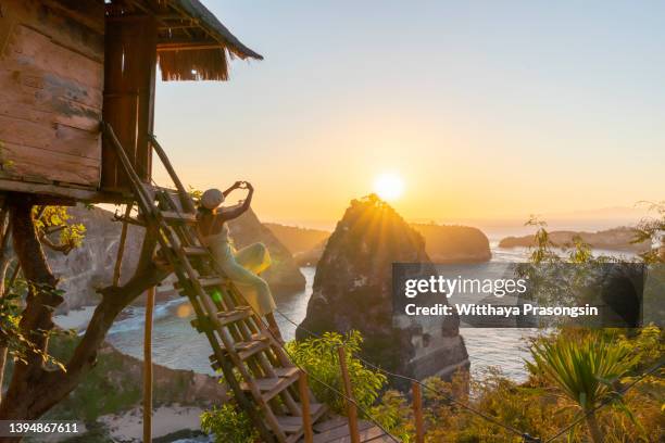 bali, indonesia, traveler on tree house at diamond beach in nusa penida island - balinese culture stock pictures, royalty-free photos & images