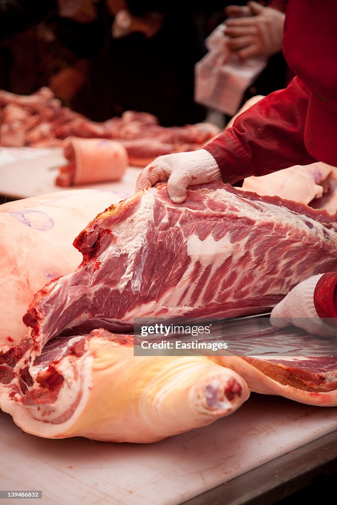 Man cut up pork in market in China