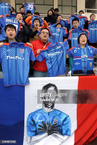 Shanghai Shenhua holding jerseys of Nicolas Anelka cheer their team during a warm-up match between Shanghai Shenhua and Hunan Xiangtao at Shenhua...