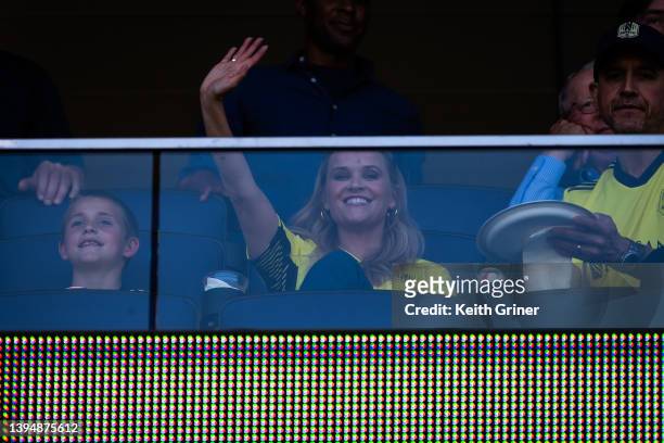 Reese Witherspoon , with her son Tennessee Toth and her husband Jim Toth, waves during the Inaugural home opener game between Philadelphia Union and...
