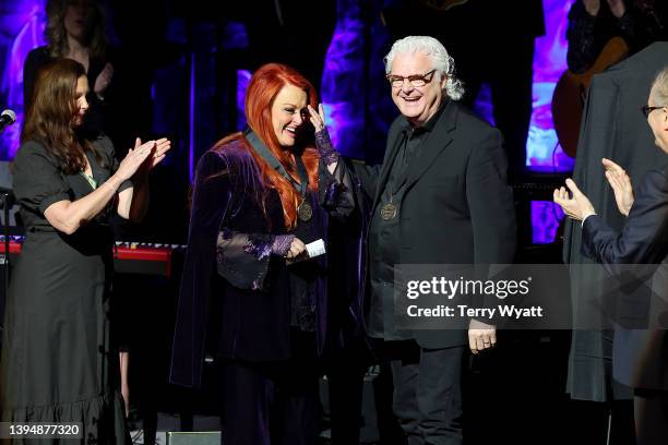 Ashley Judd accepts induction on behalf of Naomi Judd with inductee Wynonna Judd and Ricky Skaggs onstage for the class of 2021 medallion ceremony at...