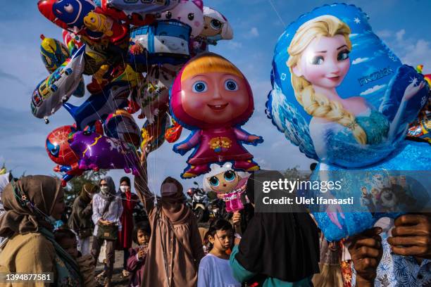 Muslims buy balloons as they attend the Eid Al-Fitr prayer on the 'sea of sands' at Parangkusumo beach on May 02, 2022 in Yogyakarta, Indonesia....